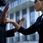 Racial discrimination at workplace, woman scolding afro-american employee