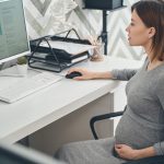 Beautiful pregnant lady using computer at work