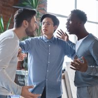 Young angry coworkers having quarrel at office