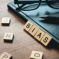Selective focus of glasses, pen, notebook and wooden alphabet of word Bias. Selective focus of glasses, pen, notebook and wooden alphabet of word Bias.