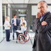 Thoughtful manager with wheelchair users in the team Thoughtful manager with wheelchair users in the team