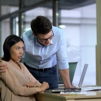 Young businessman hugging beautiful female secretary, sexual harassment, abuse