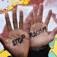 Photomontage of the hands of two men of different ethnicity in which the motto "stop racism" is written, with a multicolored background. Stop racism campaign