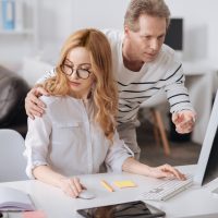 Flirting boss hugging young secretary in the office