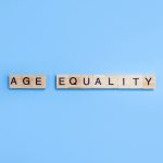 Words Age Equality. Wooden blocks with letters on blue background. Age discrimination concept. Copy space.