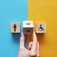 an image of an expensive person and a disabled person and an equal sign between them. Equality and acceptance of persons with disabilities