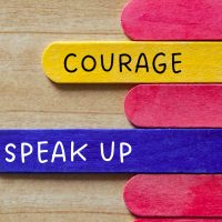 Courage and speak up text on wooden stick. Business culture value concept.