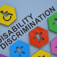 Small colorful figurines and inscription disability discrimination. Small colorful figurines and inscription disability discrimination.