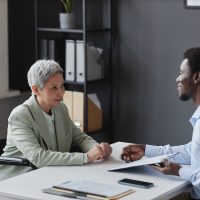 Side view mature woman with disability speaking to recruiter in job interview