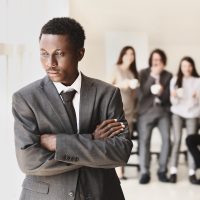 Lonely African-American businessman in office. Stop racism