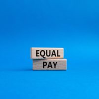 Equal Pay symbol. Wooden blocks with words Equal Pay. Beautiful blue background. Business and Equal Pay concept. Copy space. Equal Pay symbol. Wooden blocks with words Equal Pay. Beautiful blue background. Business and Equal Pay concept. Copy space.